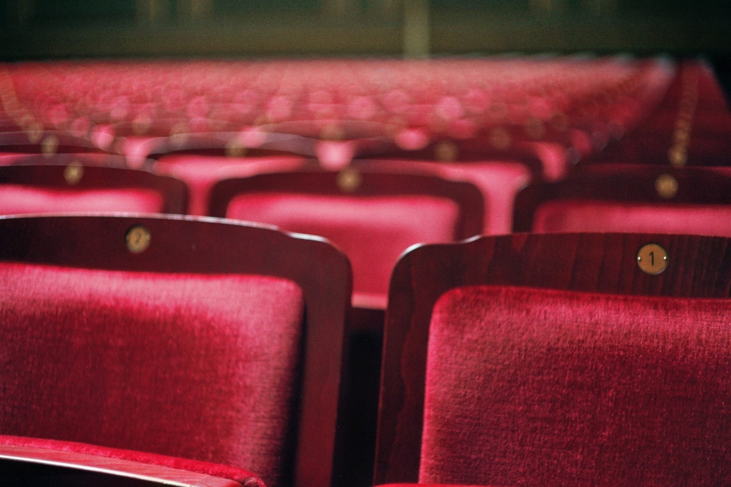 Red velvet theatre chairs in an empty theatre